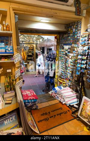 Geschenke & Souvenirs, Postkarten, Karten, Tassen, Bilder, ausgestellt auf Regalen und Regalen im Souvenirladen für Touristen in Nizza. Frankreich. (135) Stockfoto