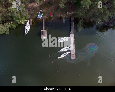 Draufsicht einer Wasserverschmutzung aus der Vogelperspektive. Ölfleck auf dem Wasser von der Yacht. Umweltkatastrophe. Stockfoto