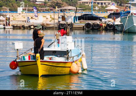 Fischer starten vom Hafen Ayia Napa in einem leuchtend gelben, traditionellen zyprischen Fischerboot. Ayia Napa, Zypern Stockfoto