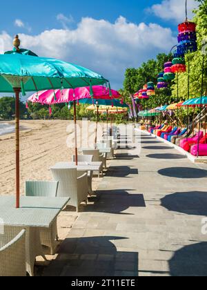 Bunte balinesische Sonnenschirme am tropischen Strand in Bali. Beach Club oder Restaurant Stockfoto