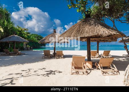Liegestühle und Sonnenschirm am tropischen Strand mit Palmen. Urlaubsbanner des Luxusresorts Stockfoto