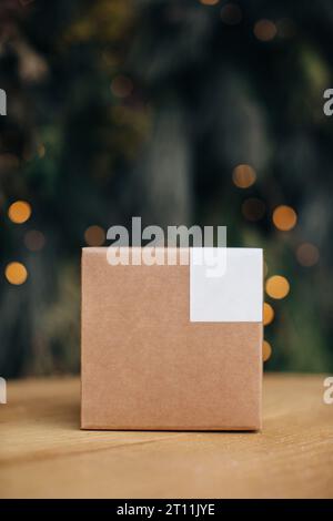 Modell. Kraftpapierboxen mit weißen Aufklebern auf weihnachtlichem Hintergrund. Stockfoto