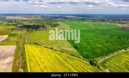 Bunte Bauernhöfe um ein kleines Dorf, Luftbild. Stockfoto