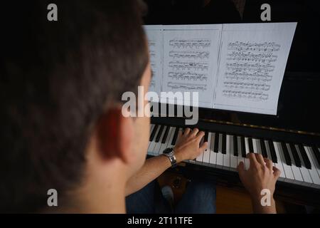 Rückansicht einer Person, die Klavier spielt Stockfoto