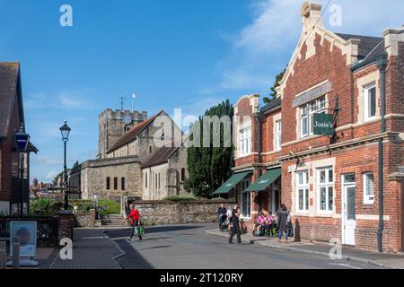 St. Peters Church in Petersfield, Hampshire, England, Großbritannien, von der St. Peter's Road aus gesehen, mit Leuten, die vor Josie's Coffee Shop sitzen Stockfoto