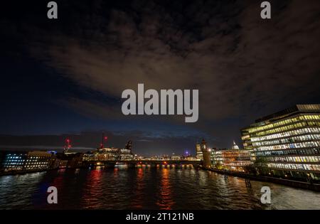 London, Großbritannien: Nachtblick über die Themse von der London Bridge aus in Richtung Blackfriars. Farbige Lichter reflektieren das Wasser. Stockfoto