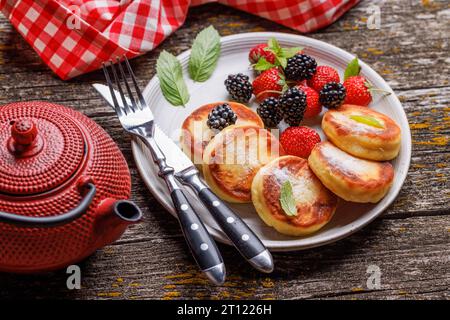 Käsepfannkuchen mit frischen Beeren und Tee Stockfoto