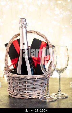 Korb mit Geschenkschachteln und Champagner Stockfoto