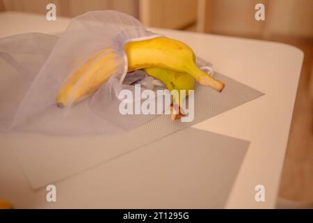 Bananen im umweltfreundlichen Netzbeutel Stockfoto