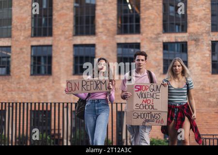Aktivisten der Generation Z mit Spruchbändern auf der Straße. Junge Studenten, die durch die Stadt marschieren, demonstrieren gegen den Klimawandel. Demonstranten Stockfoto