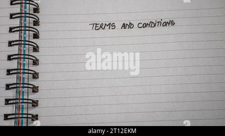 Geschäftsbedingungen, Handschriftertext auf der Büro-Agenda, Büro-Spiralnotizbuch. Kopierbereich. Stockfoto