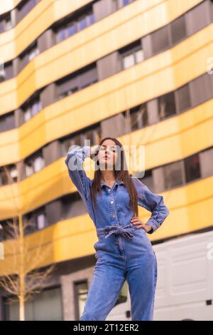 Ein junges kaukasisches Mädchen mit einem Affen-Cowboy in einem gelb-schwarzen Haus. Genießen Sie die Stadt im Urlaub, den Lebensstil eines jungen Mädchens, in einer trendigen Pose Stockfoto