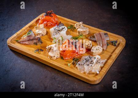 Geräucherter Tisch auf schwarzem Hintergrund, Meeresfrüchte, verschiedene Fisch- und Meeresfrüchte Stockfoto