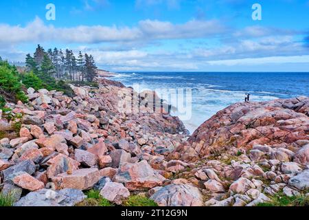 Am Lakies Head, einem beliebten Aussichtspunkt entlang des Cabot Trail in Nova Scotia, könnt ihr euch auf die Felsen stürzen. Touristen sehen so klein aus, während sie auf den Felsen stehen Stockfoto