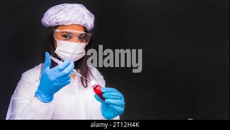 Afroamerikanische Ärztin, die den Coronavirus-Impfstoff mit Kopier- und Pastenraum vorbereitet, immunisiert die Bevölkerung, schwarzer Hintergrund, Antikörper Stockfoto