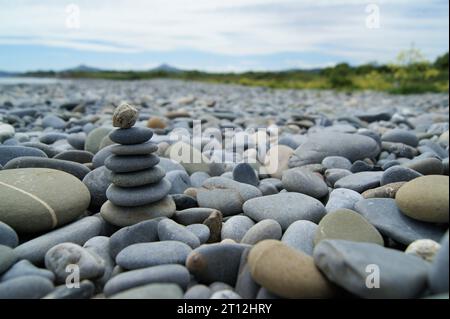 Zen-Turm an einem felsigen Strand. Verschiedene Kieselsteine am Strand. Stockfoto
