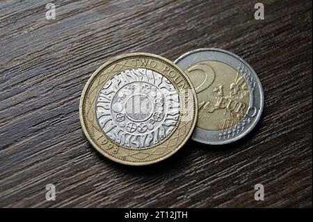 2-Pfund-Münzen und 2-Euro-Münzen. Wirtschaft und Finanzen. Stockfoto