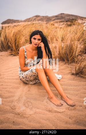 Weiße Brünette in weißem Blumenkleid am Strand von Cabo de Gata, Nijar. Andalusien, Spanien Stockfoto