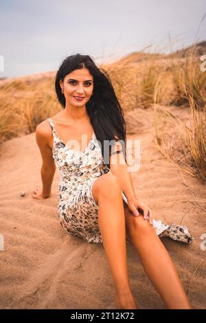 Weiße Brünette in weißem Blumenkleid am Strand von Cabo de Gata, Nijar. Andalusien, Spanien Stockfoto