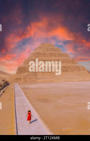 Eine junge Frau besucht die Stufenpyramide von Djoser, Sakkara. Ägypten. Die wichtigste Nekropole in Memphis. Die erste Pyramide der Welt Stockfoto