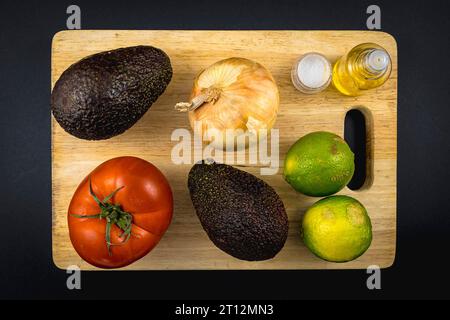 Grundzutaten, Zwiebeln, Olivenöl, Salz, Limette, Tomate und eine gute Avocado. Rezept für eine Guacamole Stockfoto