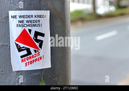 Aufkleber gegen Nazis an einem Pfahl am Straßenrand ist ein Aufkleber mit dem Text nie wieder Krieg nie wieder Faschismus Neonazis stoppen aufgebracht worden *** Aufkleber gegen Nazis Ein Aufkleber mit dem Text Neo-Nazis Krieg nie wieder Faschismus Stop Neo-Nazis wurde an einem Pfosten an der Seite angebracht von der Straße Credit: Imago/Alamy Live News Stockfoto