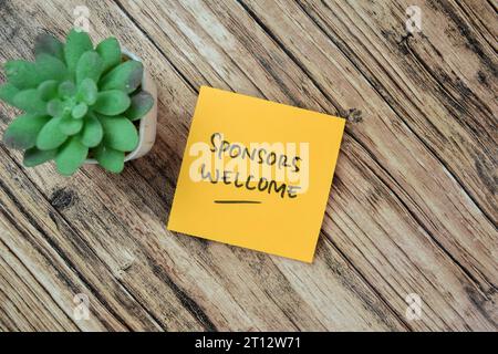 Concept of Sponsoren Willkommensschreiben auf Haftnotizen isoliert auf Holztisch. Stockfoto