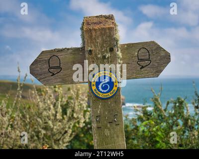 Ein altes, verwittertes hölzernes Schild, das die Route des Wales Coast Path in Pembrokeshire, Wales, zeigt Stockfoto