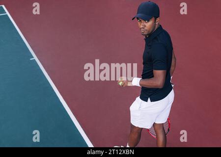 Hoher Winkel eines jungen Tennisspielers, der draußen auf dem Hartplatz steht Stockfoto