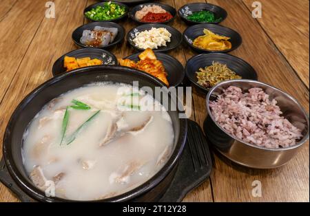 Dwaeji Gukbap, ein beliebtes koreanisches Reisgericht mit Schweinefleisch, serviert mit traditionellen Beilagen aus Kimchee, eingelegtem Rettich, gebratenen Sardellen, Konjac, Stockfoto