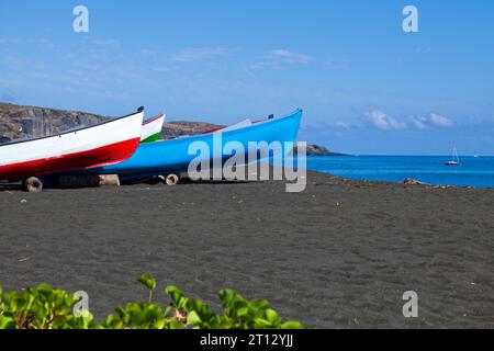 Kleine fischerboote am schwarzen Sandstrand in Saint-Paul de la Réunion. Stockfoto