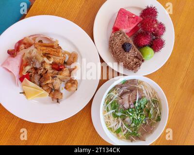 Verschiedene Teller mit Essen und Obst auf dem Tisch Stockfoto