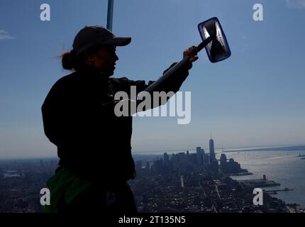 New York, Usa. Oktober 2023. Ein Arbeiter reinigt das Glas mit Blick auf das One World Trade Center und die Skyline von Manhattan von Edge Hudson Yards, dem höchsten Outdoor-Sky-Deck der westlichen Hemisphäre, am Dienstag, den 10. Oktober 2023 in New York City. Foto: John Angelillo/UPI Credit: UPI/Alamy Live News Stockfoto