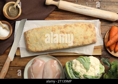 Köstlicher Strudel mit Huhn und Gemüse auf Holztisch, flach gelegen Stockfoto