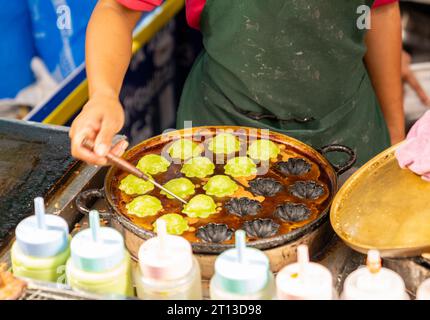 Händler pflücken modernes thailändisches Fleisch auf dem Straßenmarkt. Stockfoto