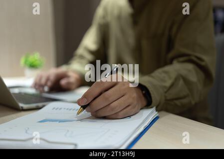 Geschäftsmann Arbeitsbericht Finanzanlageberichte Dokumente auf Laptop im Büro. Unternehmen mit Diagrammen Steuern, Planning.Marketing Data Analysis Stockfoto