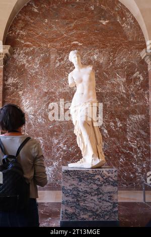 Venus de Milo Louvre. Ein Tourist mit Blick auf die Statue Venus de Milo, Louvre Museum, Paris, Frankreich. Skulpturengalerie im Louvre. Stockfoto