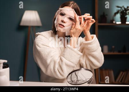 Beauty-Bloggerin, die eine feuchtigkeitsspendende Gesichtsmaske aufnimmt und ein Video-Tutorial für ihren Blog aufnimmt, teilt Beauty-Geheimnisse in sozialen Netzwerken. Kopierbereich Stockfoto