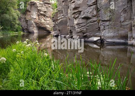 Hintergrund Felsen und Fluss in Schlucht oder Schlucht. Der Gebirgsfluss fließt in den Canyon vor dem Hintergrund der Felsschlucht. Wunderschöne mächtige Felsen hoch in den Bergen Stockfoto