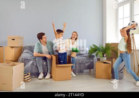 Aktive, fröhliche Kinder genießen den beweglichen Tag und spielen, Spaß haben und in einem neuen Haus herumspielen. Stockfoto