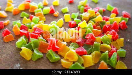 Farbige kandierte Früchte auf einem Holzbrett. Kandierte Schälstücke Stockfoto