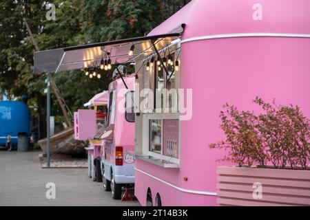 Pinkfarbene Eiswagen auf der Straße in der Stadt, mobiler fairer Handel mit Food Trucks. Stockfoto