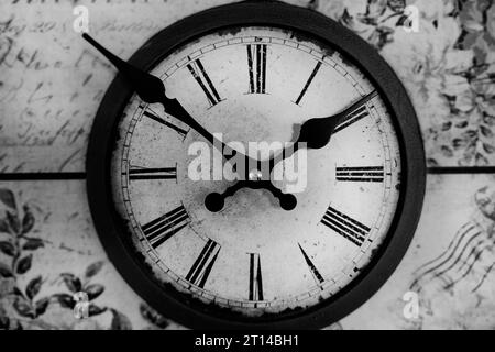 Alte Vintage-Uhr auf hölzernem Hintergrund. Rundes Zifferblatt der Wanduhr. Klassisches Schwarzweiß-Foto. Konzeptzeit läuft. Zeitkonzept. Uhr, Zeit Stockfoto