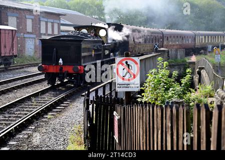 Beachten Sie, dass die Passagiere die Strecke nicht an der Keighley Station auf der Keighley & Worth Valley Railway überqueren dürfen, wenn sich ein Dampfzug nähert. Stockfoto