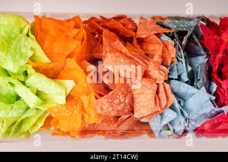 Farben von Crackern. Chips in einer Röhre, Chips in einem Glasbehälter, verschiedene Arten von Snacks. Konzept ungesunde Nahrung. Stockfoto