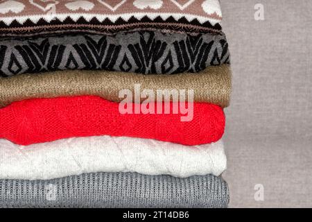 Ein Stapel Pullover, Pullover. Ein Haufen farbiger, wolliger Pullover. Schichten, die Textur der Kleidung Stockfoto