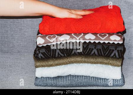 Ein Stapel Pullover, Pullover. Ein Haufen farbiger, wolliger Pullover. Schichten, die Textur der Kleidung Stockfoto