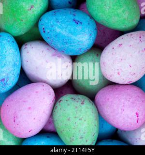 Leuchtende und farbenfrohe Mini-Milchschokoladeneier mit gesprenkelten und süßen pastellfarbenen Zuckerschalen bereit für Osterfeiern. Stockfoto