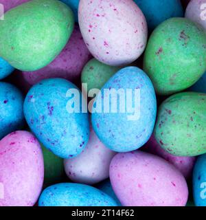 Leuchtende und farbenfrohe Mini-Milchschokoladeneier mit gesprenkelten und süßen pastellfarbenen Zuckerschalen bereit für Osterfeiern. Stockfoto