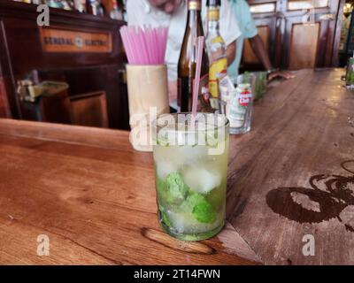 Havanna, Kuba. Oktober 2023. In der Bar La Bodeguita del Medio in der Altstadt der kubanischen Hauptstadt wird ein Mojito serviert. Der Mojito besteht aus Rum, Limettensaft und Zucker, sein eigener Geschmack erhält ihn durch Zugabe von Minzblättern. Das ganze wird durch Zerkleinern gemischt und mit Natronlauge aufgefüllt. Quelle: Nick Kaiser/dpa/Alamy Live News Stockfoto